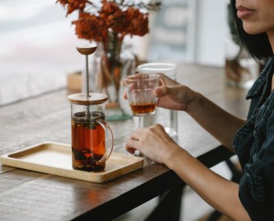 tee kann naine laud Photo by Charlotte May: https://www.pexels.com/photo/crop-woman-enjoying-herbal-tea-at-high-table-5946805/