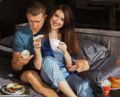 Romantic Couple Sitting on the Bed while Eating Together