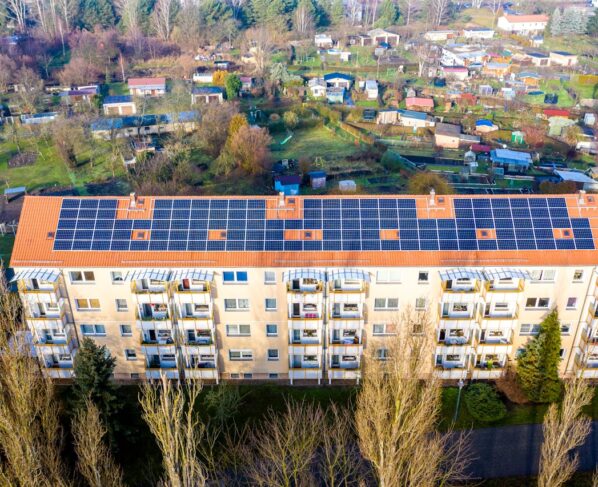 Photo by Solarimo GmbH: https://www.pexels.com/photo/drone-shot-of-a-building-with-solar-panels-on-roof-4230062/