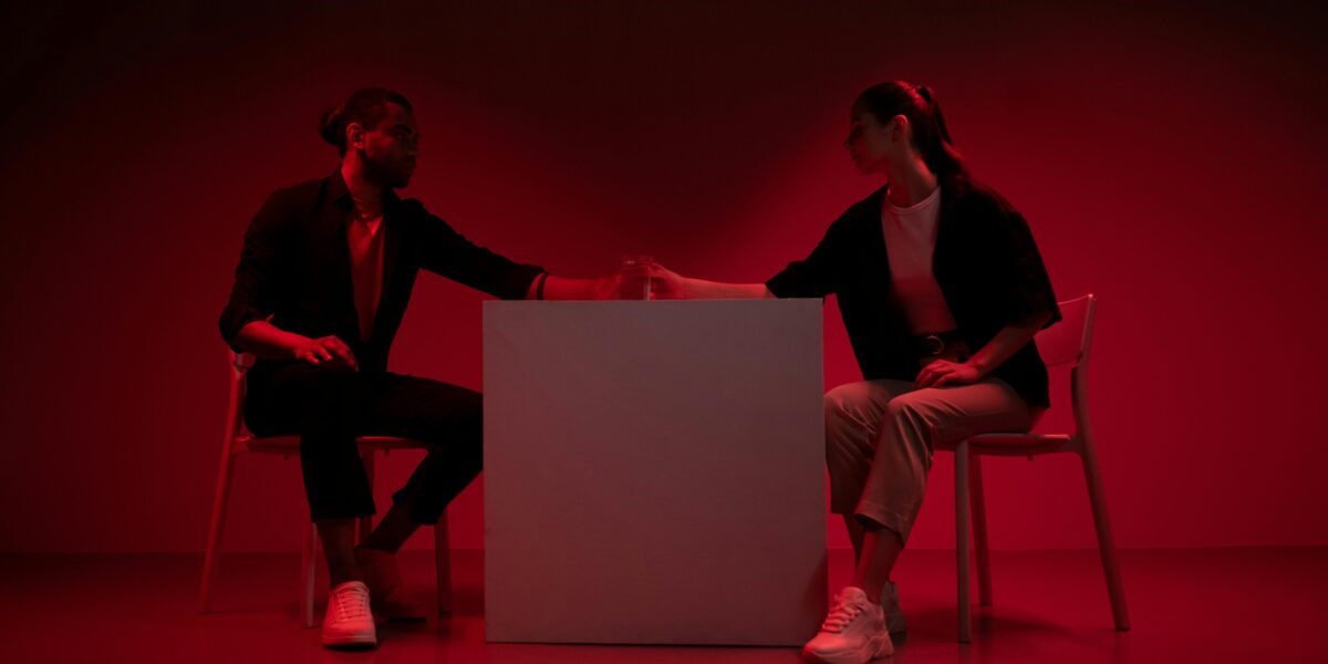 Photo by Ron Lach : https://www.pexels.com/photo/two-people-sitting-beside-a-table-in-red-light-9895035/