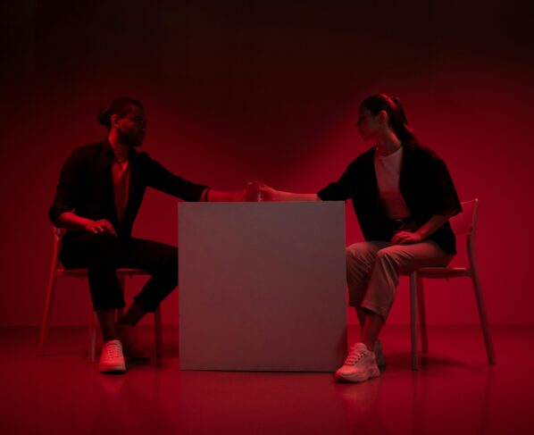 Photo by Ron Lach : https://www.pexels.com/photo/two-people-sitting-beside-a-table-in-red-light-9895035/