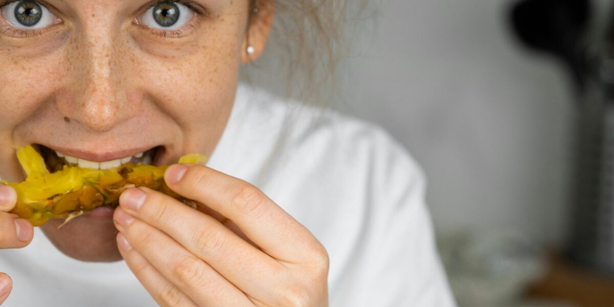 Photo by SHVETS production: https://www.pexels.com/photo/happy-woman-eating-pineapple-at-home-7194858/