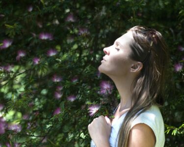 Photo by Alex P: https://www.pexels.com/photo/woman-closing-her-eyes-against-sun-light-standing-near-purple-petaled-flower-plant-321576/