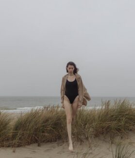 Photo by Yaroslav Shuraev: https://www.pexels.com/photo/woman-in-black-swimsuit-standing-on-green-grass-field-near-body-of-water-5980141/