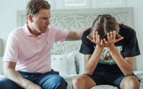 Photo by Kindel Media: https://www.pexels.com/photo/man-in-a-pink-shirt-sitting-beside-a-teenager-crying-8550682/